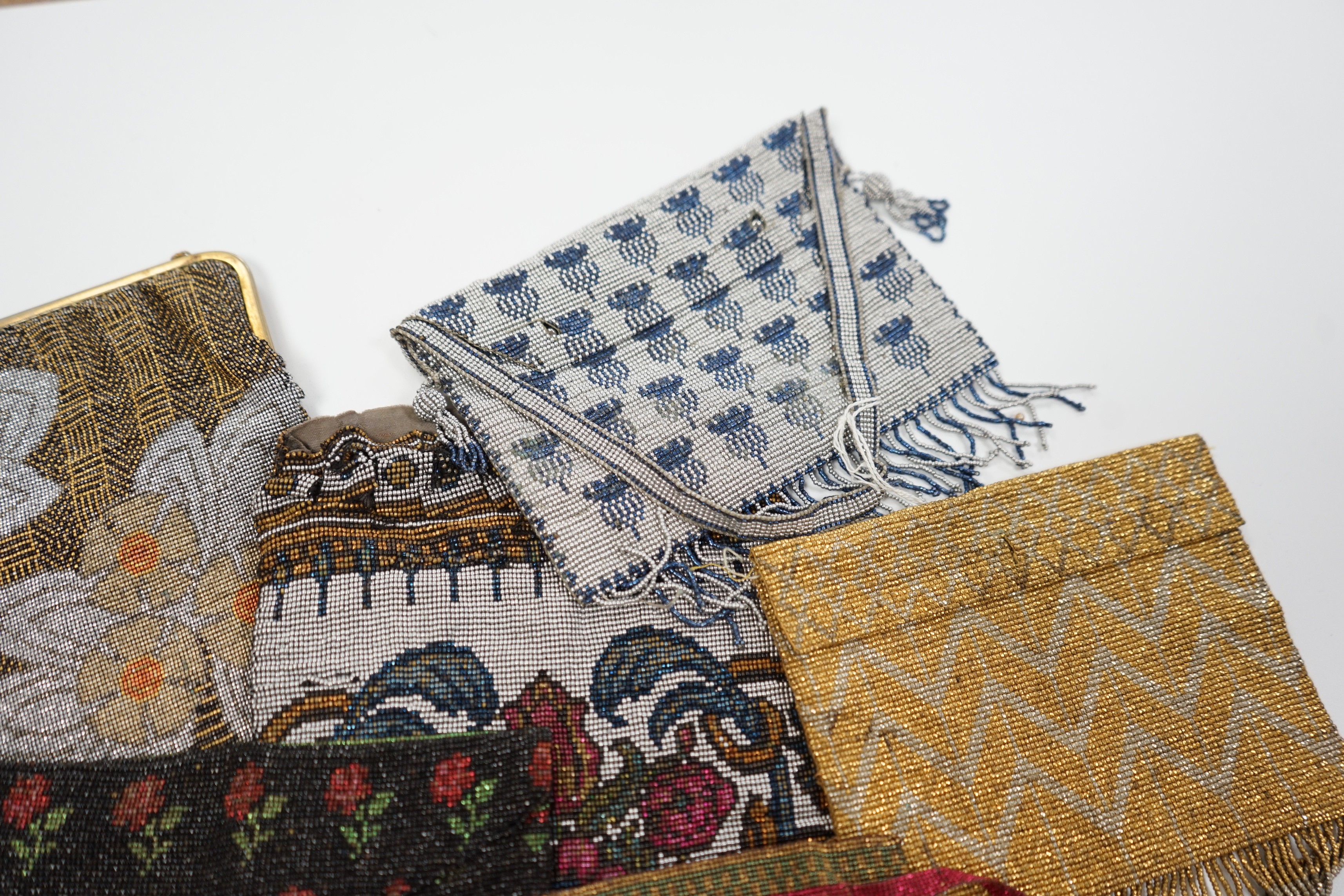 Seven late 19th century multicoloured and designed cut steel evening bags and a small coin purse (8)